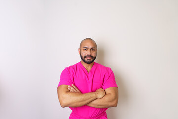 Fototapeta premium Beautician wearing pink uniform crossing his arms, showing confidence and professionalism