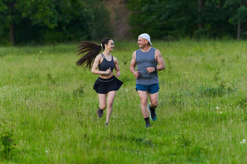 Fototapeta premium Fit couple running outdoors together...