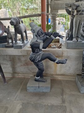 The image features a stone statue of Kannappa Nayanar, a revered saint in the South Indian Saiva Siddhanta tradition.