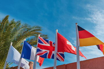 Flags of different European countries against background of blue sunny sky. International flags Concept. Set of flags.