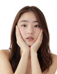 Fototapeta premium A young woman with long, straight brown hair, wearing a white tank top, gently holds her face with both hands.