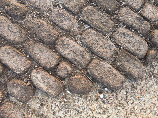 Stone pavement texture around the edge of the lake. Abstract background of old cobblestone pavement at Pamekasan, Indonesia.