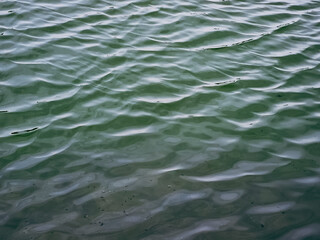 Blue green surface of the ocean in Pamekasan, Indonesia with gentle ripples on the surface.