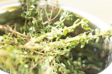 Close-up of dried thyme sprigs in a metal bowl.  Perfect for culinary or herbal background.