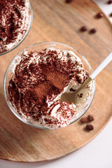 Traditional Italian dessert tiramisu in glasses on white table. Soft focus