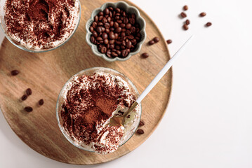 Traditional Italian dessert tiramisu in glasses on white table. Soft focus