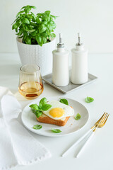 Croque madam sandwich with cheese and egg on white wooden table.