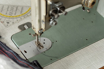 Detailed view of an antique sewing machine needle and presser foot.