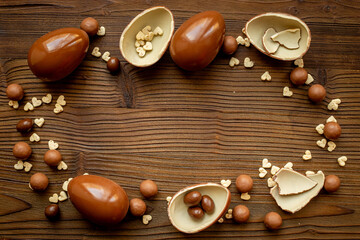 Chocolate background. Broken and whole chocolate eggs, top view