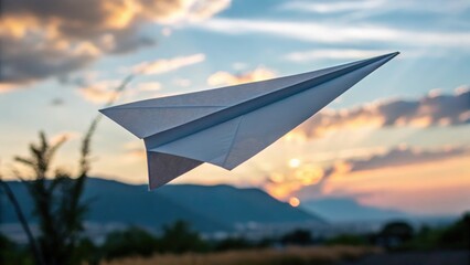 Fototapeta premium Paper airplane gliding through a vibrant sunset landscape, symbolizing dreams and adventure