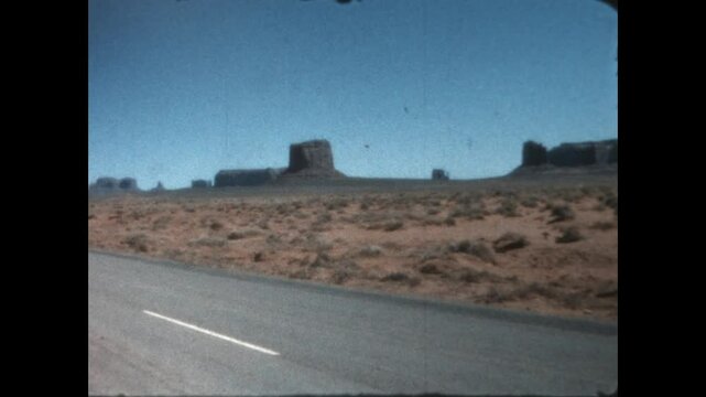 Driving in the Desert 1963 - A car drives on US Route 160 through Monument Valley, within the Navajo Nation, in 1963.
