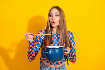 Young woman holding a pot and ladle while cooking in a bright and colorful setting