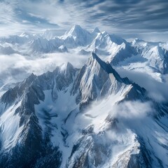Fototapeta premium Drone capture of a breathtaking mountain range covered in snow, with clouds casting dynamic shadows over the peaks