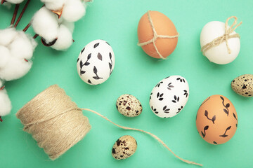 Easter background - white easter egg with flowers inside on mint background. Happy easter, spring, summer floral concept