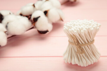 White cotton stricks on pink wooden background. Eco friendly. Hygienic cotton swabs for ears. Top...