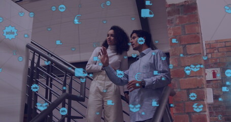 Image of network of connections with icons over diverse colleagues discussing work in office