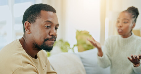 African couple, conflict and fight on sofa in home living room for questions, anger or mistake in...