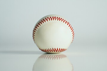 White baseball sits centered on reflective surface, showcasing i