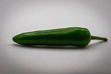 Chillies, isolated, on a wooden chopping board, whole and chopped