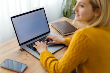 Woman working on laptop in cozy indoor workspace