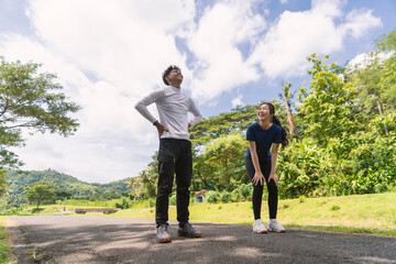 Obraz premium active asian young couple take a break from exercise at rural area