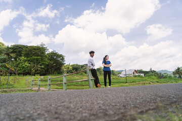 Obraz premium active asian young couple chitchat with each other while take a break from exercise at rural area