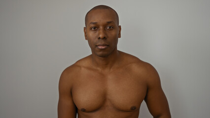 Fototapeta premium Young attractive african american man standing isolated against a white background wall with a confident expression and bare chest.