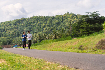 Obraz premium active asian young couple jogging and running exercise at rural area