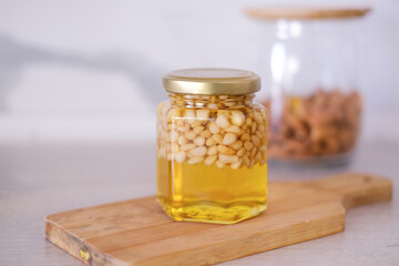  Cedar nuts with honey in glass yars on vnit vooden boards.