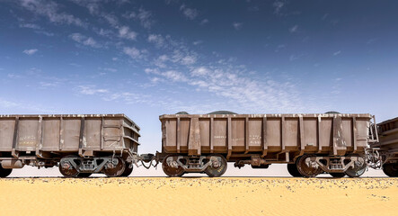 Side view of ore wagons on a train in the desert of Mauritania