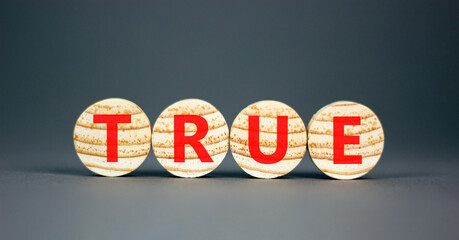True symbol. Concept word True on beautiful wooden circles. Beautiful grey table grey background....