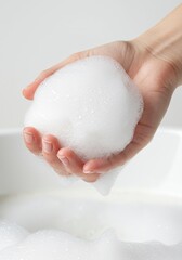 Hand Holding a Ball of Luxurious White Foam