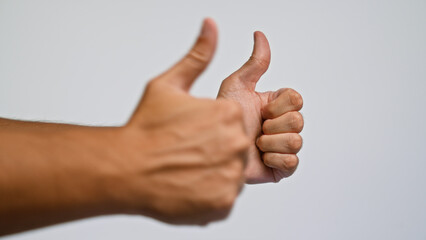 Two hands showing thumbs up against a plain background highlighting approval and positivity by a man