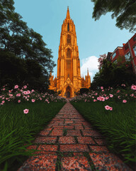 Naklejka premium Stunning Vector Art of Gothic Cathedral Tower Amid Lush Greenery with Brick Path and Floral Gardens Under Clear Blue Sky - Architectural Digital Illustration
