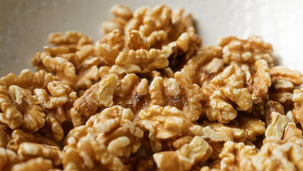 Closeup image of shelled walnuts in a bowl showing detailed texture and natural color