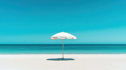 A white beach umbrella stands on a sunny tropical shoreline