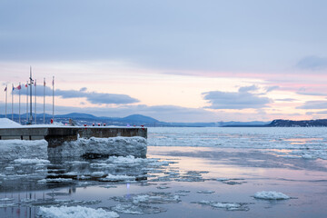 Fototapeta premium Early morning blue hour winter sunrise view of wharf in the old port along the St. Lawrence River coastline, Quebec City, Quebec, Canada