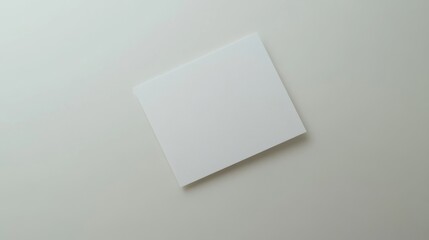 Blank white card on a flat surface, symbolizing simplicity and clarity in design.
