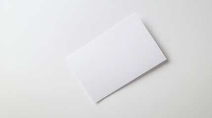 Blank white card on a flat surface, symbolizing simplicity and clarity in design.
