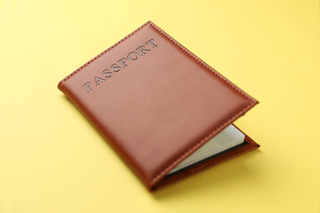 Passport in bright cover on yellow background, closeup