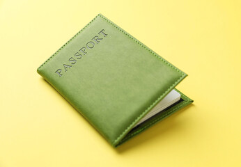 Passport in bright cover on yellow background, closeup