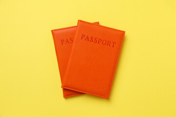 Passports in bright covers on yellow background, top view