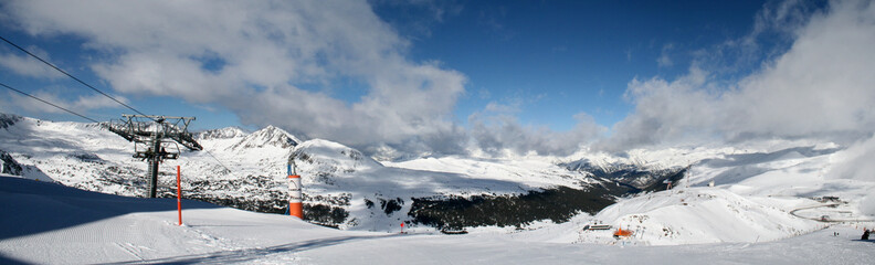 Fototapeta premium A magnificent panorama of the snow-capped mountains of Andorra, illuminated by the soft winter sun.