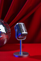 Retro microphone close-up with neon lights against the background of a red curtain. Karaoke, comedy or music show in a bar restaurant with a microphone and bright lighting. Podcast studio, workspace