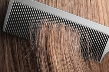 Brushing hair with plastic comb, closeup view