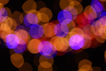 Blurred view of colorful lights on black background, bokeh effect