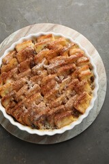 Delicious bread pudding with raisins and cinnamon on grey table, top view
