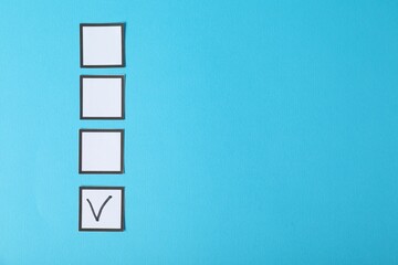 One checkbox with tick mark among others on light blue background, flat lay. Space for text