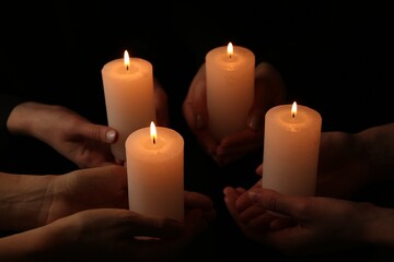 Women with burning candles on dark background, closeup