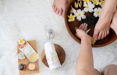 Woman indulges in blissful foot massage at luxurious spa salon while masseur give reflexology therapy in gentle day light ambiance resort or hotel foot spa. Quiescent